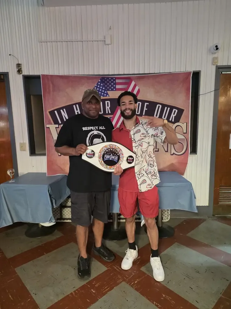 A boxer holds a championship belt inside the post hall
