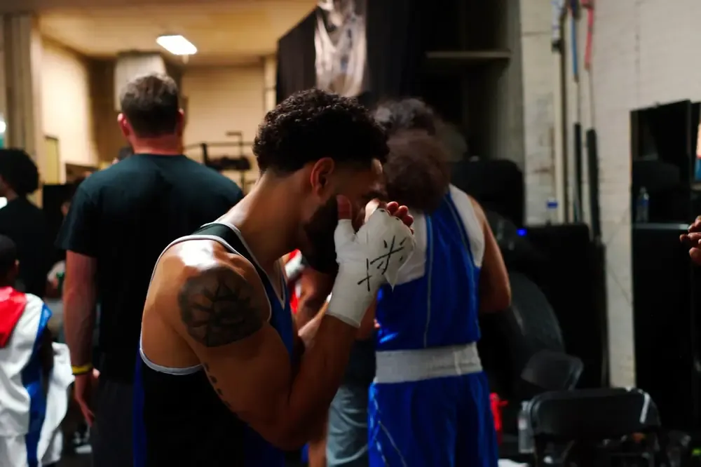A boxer with wrapped hands keeps his guard up before a bout