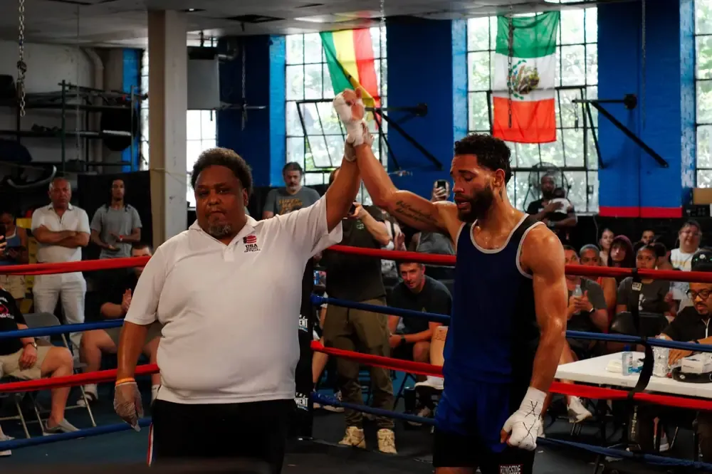 A referee raises the winning boxer's hand in the ring at Post 101